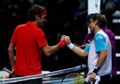 Second seeded Roger Federer (L) shakes hands with David Ferrer of Spain after defeating him during their men's singles first round match during the ATP World Tour Finals in London