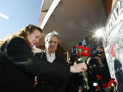 Pilar Manjón deposita flores en la estación Atocha, junto a Ricardo Martínez, de UGT.