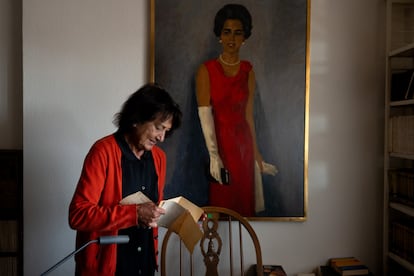Elisa Delibes revisa unos papeles de su padre frente al cuadro ‘Mujer de rojo sobre fondo gris’.