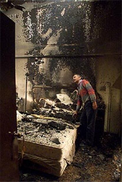 Un hombre muestra cómo el fuego a arrasado su vivienda, situada en una ciudad al este de Sydney.