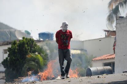 Un manifestante camina cerca de una barricada durante los enfrentamientos con la policía, en Cotiza.