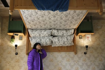 A visitor poses inside an upside-down house created by a group of Taiwanese architects at the Huashan Creative Park in Taipei, Taiwan, Tuesday, Feb. 23, 2016. With a build price of $600,000 and over 300 square meters (3,230 square feet) of floor space filled with real home furnishings, the upside-down house will continue to be on display to visitors until July 22. (AP Photo/Wally Santana)