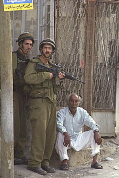 Dos soldados israelíes retienen a un civil palestino en Nablús.