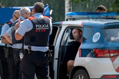 Agentes de los Mossos, custodian al detenido, en el interior del vehículo.