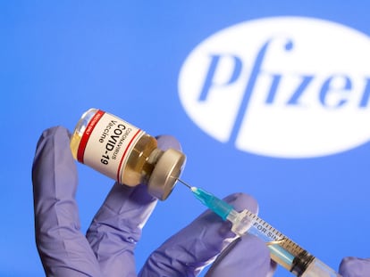 Una persona extrae la vacuna contra la covid-19 con una jeringuilla médica de un vial de Pfizer.