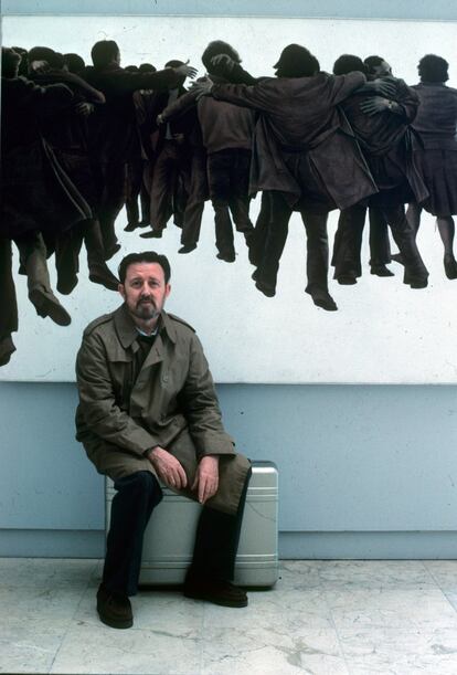 El pintor Juan Genovés, sentado delante de su cuadro 'El abrazo', símbolo de la Transición, en 1988.