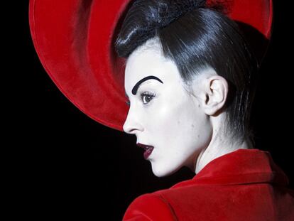 Una modelo luce la colección de Maya Hansen con chaqueta y tocado rojos.