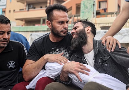 Un hombre sostenía este domingo el cuerpo de un niño antes de que fuera enterrado en Jan Yunis.