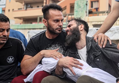 Un hombre sostenía este domingo el cuerpo de un niño antes de que fuera enterrado en Jan Yunis. 