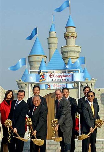 Robert Iger (el primero por la izquierda empuñando una pala) y Michael Eisner (tercero), en un parque Disney de Hong Kong.