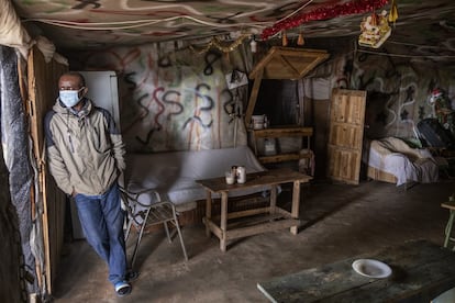 Ato, posa en su bar del asentamiento de El Bosque en Lucena del Puerto, en marzo de 2021.