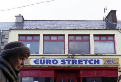 Una mujer pasa junto a un negocio en Buncrana (Irlanda).