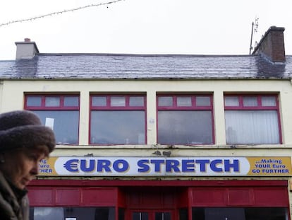 Una mujer pasa junto a un negocio en Buncrana (Irlanda).