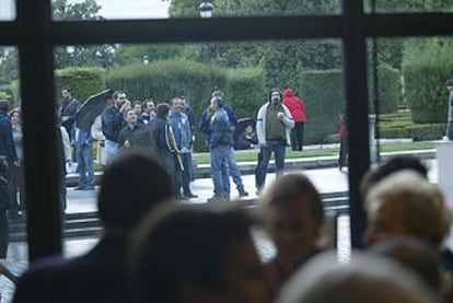 Trabajadores del Real se manifiestan ayer fuera del teatro, minutos antes del comienzo de la función.