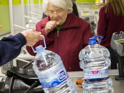 Una mujer compra agua embotellada en Alzira.