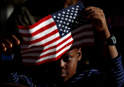 Un niño, con una bandera de Estados Unidos.