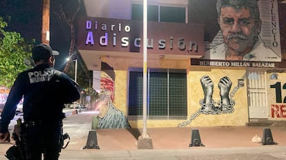 Un policía acude la noche del jueves a la sede del diario Adiscusión.  En la fachada, un mural con el rostro del fundador, Humberto Millán Salazar, asesinado en Culiacán en 2011. 