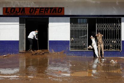 Al menos 14 personas han muerto en Muçum. En la imagen, una mujer limpia la entrada de una tienda del municipio afectada por el fenómeno meteorológico. 