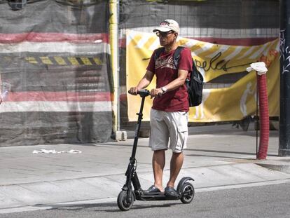 Un hombre circula en patinete eléctrico en el barrio de Sans