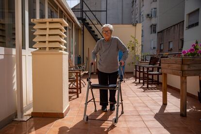 Trinidad López, de 103 años y operada de una fractura de fémur en enero, camina con su andador por la terraza de la residencia en la que vive en Barcelona.