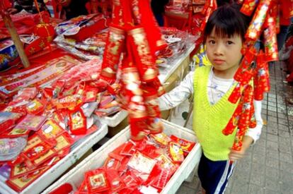 Una dulce niña no sabe lo que hace cuando ofrece tracas ensordecedoras a los clientes de un mercadillo de Año Nuevo. Además, los envoltorios rojos ensucian los ríos, ya que es basura que no se trata.