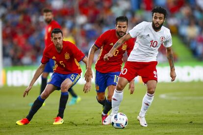 Sergio Busquets y Cesc Fábregas con el centrocampista de la selección de Georgia Okriashvili, durante el partido amistoso que disputan hoy en el Coliseum Alfonso Pérez de Getafe.