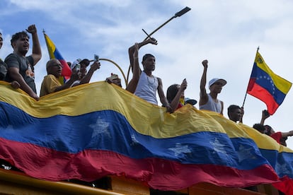 Ciudadanos portan banderas de Venezuela durante la protesta en Caracas, el lunes. 