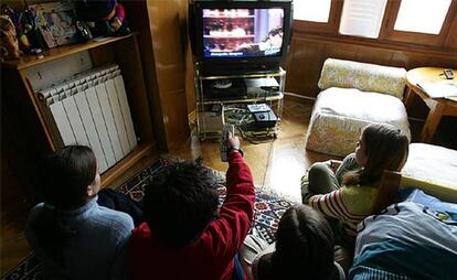 Un grupo de niños observa las emisiones de televisión.