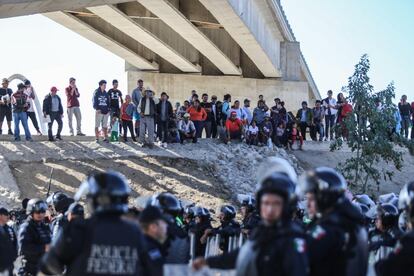Un grupo de personas tratan de cruzar la garita El Chaparral, de la ciudad de Tijuana.