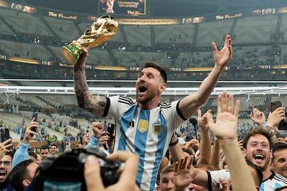 Lionel Messi celebra con el trofeo ante los aficionados tras ganar la final del Mundial de fútbol entre Argentina y Francia en el estadio Lusail de Lusail, Catar, en 2022.