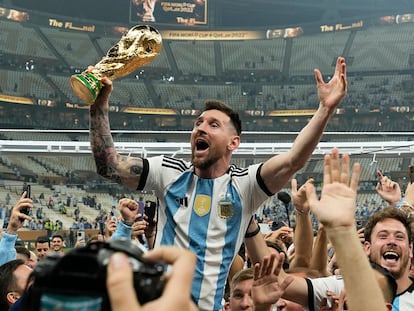 Lionel Messi celebra con el trofeo ante los aficionados tras ganar la final del Mundial de fútbol entre Argentina y Francia en el estadio Lusail de Lusail, Catar, en 2022.