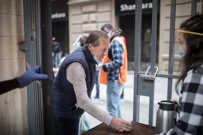 Un hombre recoge comida en la parroquia de Santa Anna.