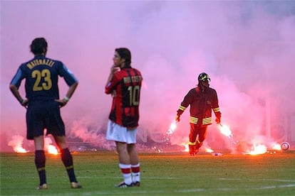 Materazzi y Rui Costa observan, consternados, las bengalas sobre el césped y esperan la decisión del árbitro.