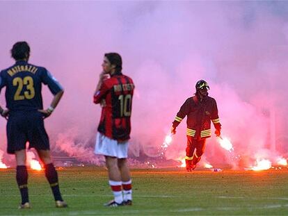 Materazzi y Rui Costa observan, consternados, las bengalas sobre el césped y esperan la decisión del árbitro.