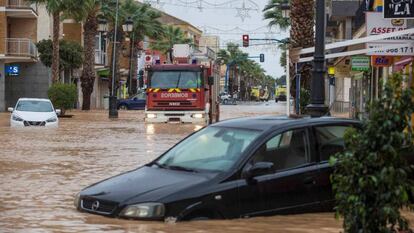 Un camión de bomberos pasa por la avenida Libertad de Los Alcázares, inundada por las fuertes lluvias.