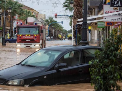 Un camión de bomberos pasa por la avenida Libertad de Los Alcázares, inundada por las fuertes lluvias.