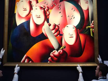 Dos técnicos de Christie’s, durante una subasta celebrada en Londres, con la obra ‘Retrato de grupo con sandía’, de Oleg Tselkov.