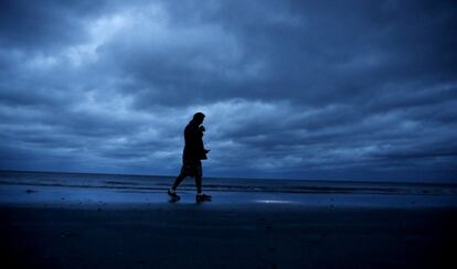 Russ Lewis busca camina a lo largo de a playa durante el acercamiento  del huracán Florence a Myrtle Beach. 