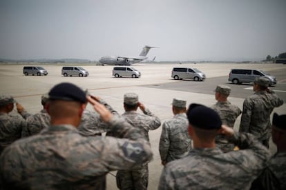 Soldados estadounideses frente a una fila de vehículos que transportas los cuerpos de 55 militares fallecidos en la Guerra de Corea.