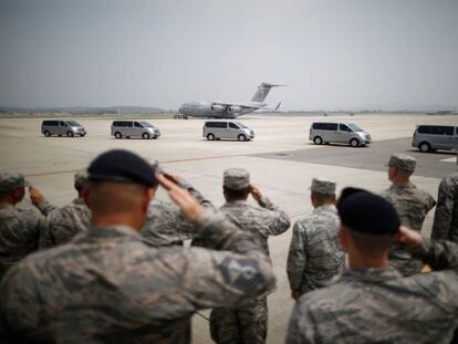 Soldados estadounideses frente a una fila de vehículos que transportas los cuerpos de 55 militares fallecidos en la Guerra de Corea.