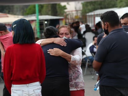 Familiares de víctimas del accidente en el metro de Ciudad de México se abrazan a las puertas de la oficina forense de Iztapalapa.