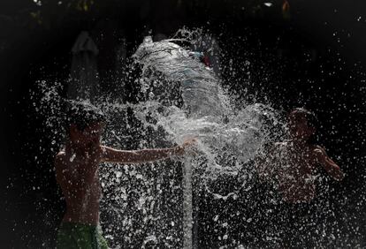 El viernes se producirá una ligera bajada de las temperaturas mínimas en el norte, aunque la noche volverá a ser especialmente cálida en el tercio sur, con valores que no bajarán de los 25 grados en el valle del Gualdalquivir, puntos del valle del Tajo, y, en general, en el sureste de Andalucía. En la imagen, varios niños se refrescan en una fuente pública de la plaza Yamaguchi de Pamplona.