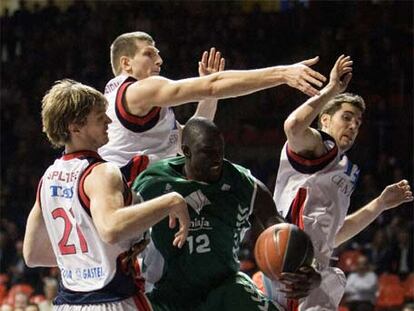 Ndong, <i>pívot</i> del Unicaja, intenta capturar un rebote entre Splitter, Teletovic y Vidal, del Tau.