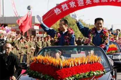 Los <i>taikonautas</i> Fei Junlong y Nie Haisheng, ayer en su regreso triunfal a Pekín.
