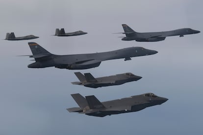 In this photo provided by South Korean Defense Ministry, US Air Force B-1B bombers, center, F-22 fighter jets and South Korean Air Force F-35 fighter jets, bottom, fly over South Korea Peninsula.