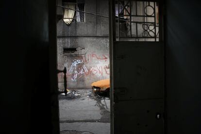 Un vehículo oxidado es visto delante de una casa abandonada.