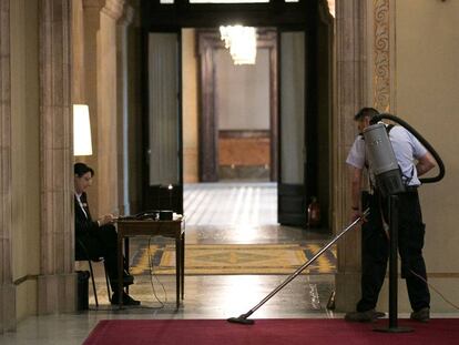 Un empleado del Parlament limpia las alfombras de la Cámara autonómica este jueves.