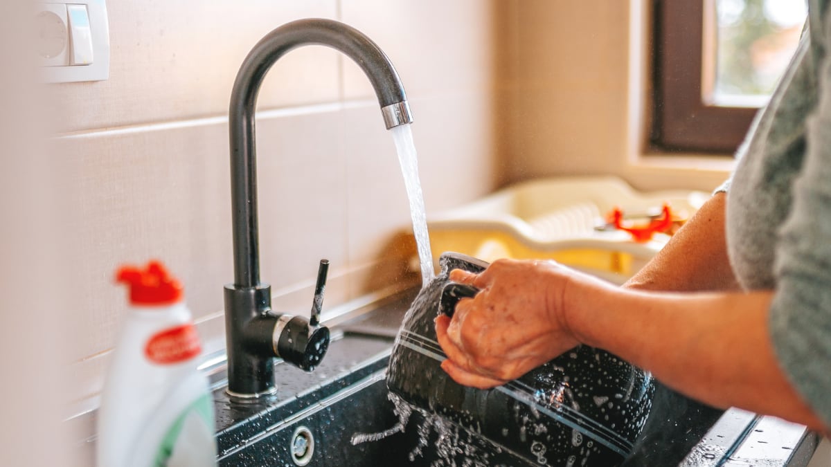 A person washing the dishes.