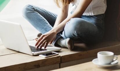 Una joven hace un curso en su m&oacute;vil o tableta.