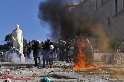 Policías lanzan piedras contras manifestantes en Atenas.